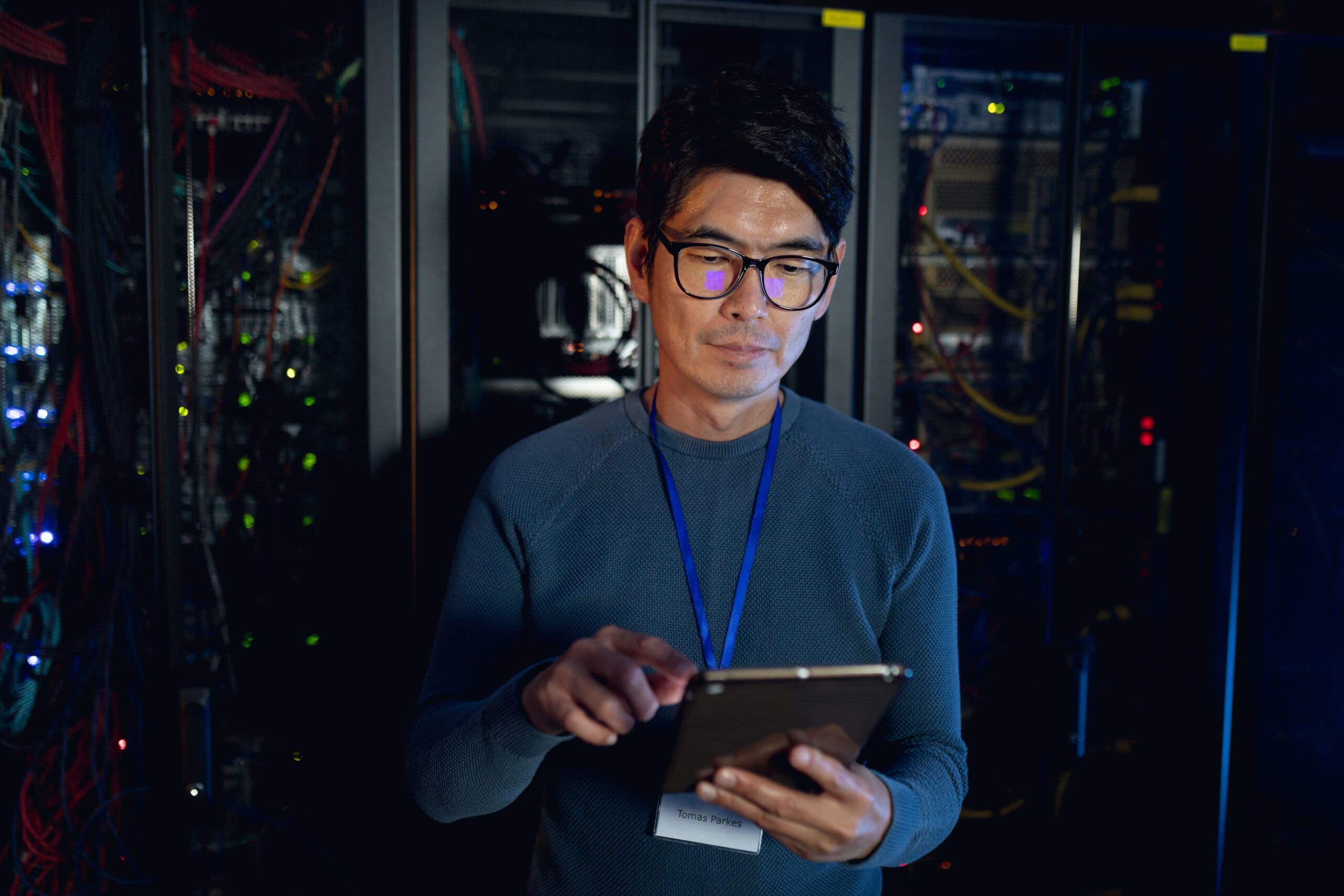 Asian male engineer using digital tablet in computer server room